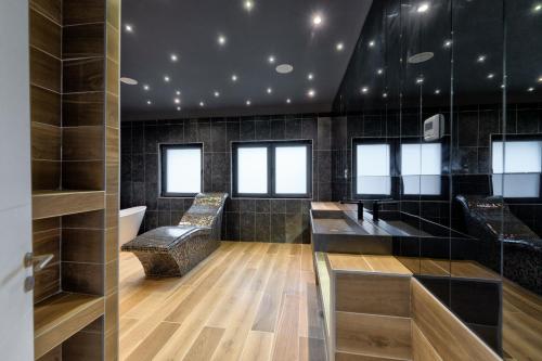 a barbershop with black tiled walls and windows at Hotel Montanova in Zlatibor