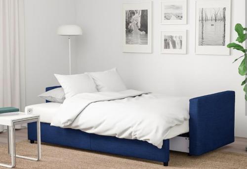 um quarto com uma cama azul e lençóis brancos em Kope, Jagoda 8 - Studio 2 em Slovenj Gradec