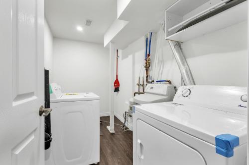a white laundry room with a washer and dryer at Modern 1 Bedroom + Den in Cambridge in Cambridge