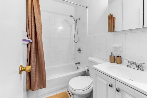 a white bathroom with a toilet and a sink at Welcome to “Sunny Park Slope Retreat”! in Brooklyn
