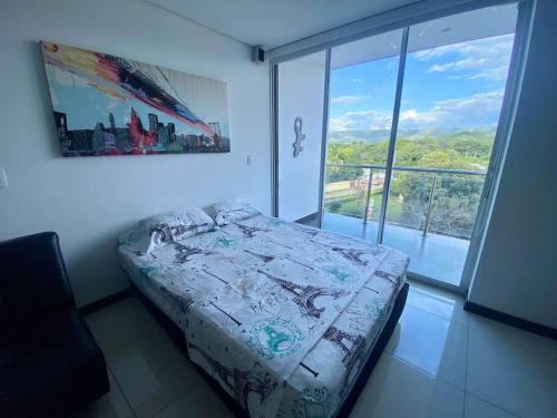 ein Schlafzimmer mit einem Bett und einem großen Fenster in der Unterkunft Disfruta hermoso apartaestudio in Ricaurte