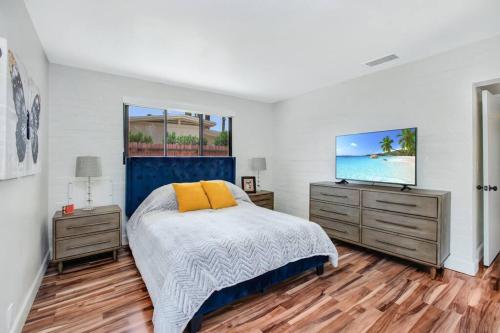 a bedroom with a bed and a flat screen tv at Close to downtown PS - Hike, Bike, Swim, Relax in Palm Springs