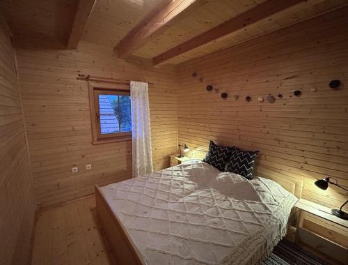 ein Schlafzimmer mit einem Bett in einem Blockhaus in der Unterkunft A View to a Hill 