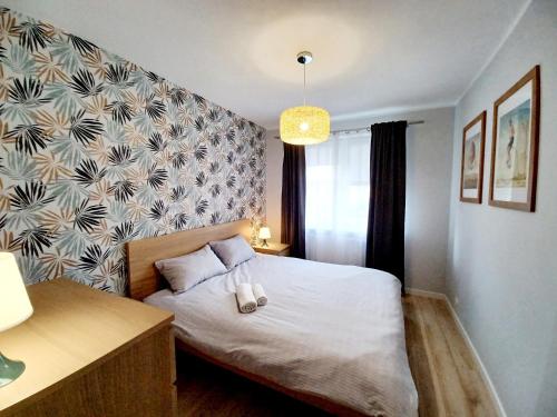 a bedroom with a bed and a wall at Kolory Warmii Apartament Niebieski in Olsztyn