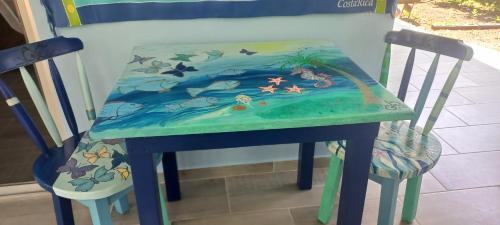 a table with a painting of the ocean on it at Casa Katharina in Cahuita
