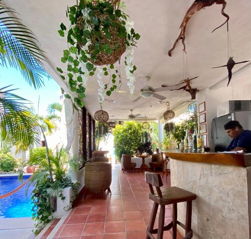 a man sitting at a bar in a restaurant at Hotel Para Ti - Adults Only in Holbox Island