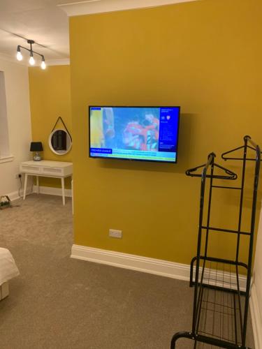 uma sala de estar com uma televisão de ecrã plano na parede em The Vicarage em Sunderland