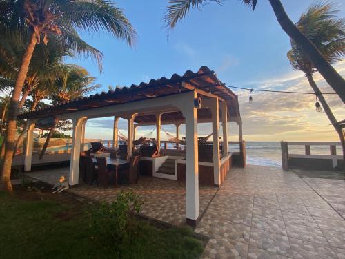 a gazebo on the beach near the ocean at SOLID Surf Camp Hostel Nicaragua in Transito