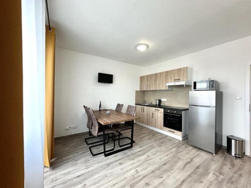a kitchen with a wooden table and a refrigerator at Sky Apartments 511 in Plzeň
