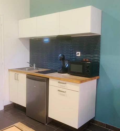 une petite cuisine avec un micro-ondes et un évier dans l'établissement Les 6 Phocéens, à Marseille