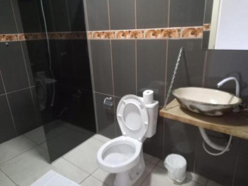 a bathroom with a toilet and a sink at Hotel Caçula São Gabriel in São Gabriel