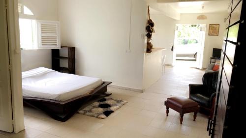 a bedroom with a bed and a chair at Appartement Topaze in La Trinité