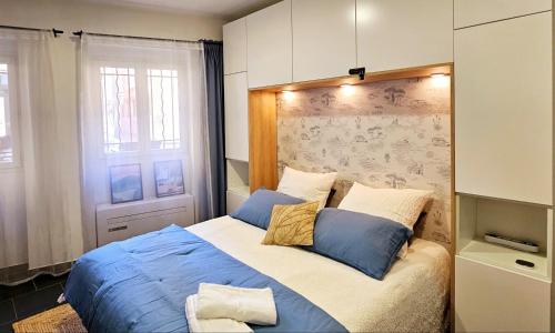 Un dormitorio con una cama con sábanas azules y una ventana. en Les 6 Phocéens, en Marsella
