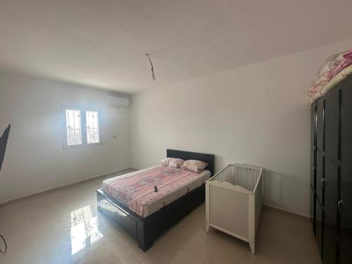 a bedroom with a bed and a crib in it at Villa Medenine in Medenine