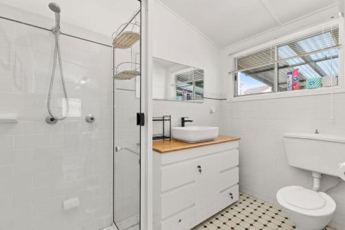 a bathroom with a shower and a toilet and a sink at The Gunyah by Experience Jervis Bay in Huskisson
