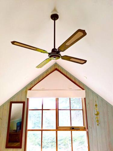 a ceiling fan in a room with a window at Alyeska Loft - Apollo Bay studio loft apartment in Apollo Bay