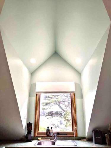 a bathroom mirror with a sink and a window at Alyeska Loft - Apollo Bay studio loft apartment in Apollo Bay