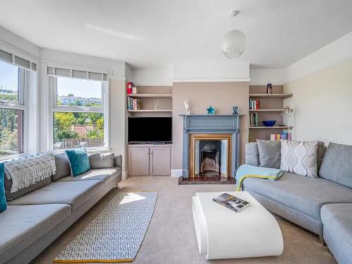 a living room with a couch and a fireplace at Sea View House in Cornwall Fishing Village in St Austell