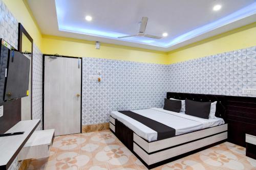 a bedroom with a bed and a tv in it at Super OYO Anandalok Guest House in Kolkata