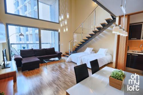 a living room with a bed and a staircase at Ohmyloft Valencia in Burjasot