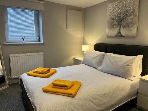 a bedroom with a bed with two towels on it at Stylish 1 Bedroom, 2 bed Basement Flat With Free Parking in Sale