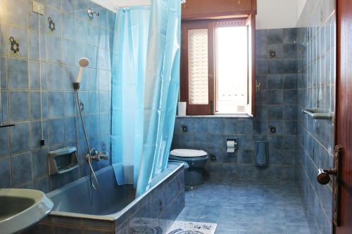 a blue bathroom with a toilet and a sink at Camera a Grammichele in Grammichele