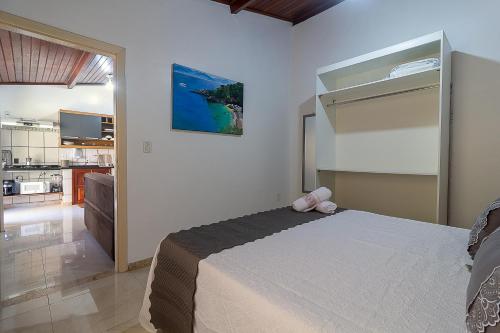 a bedroom with a large bed and a kitchen at Villa Sunset in Arraial d'Ajuda