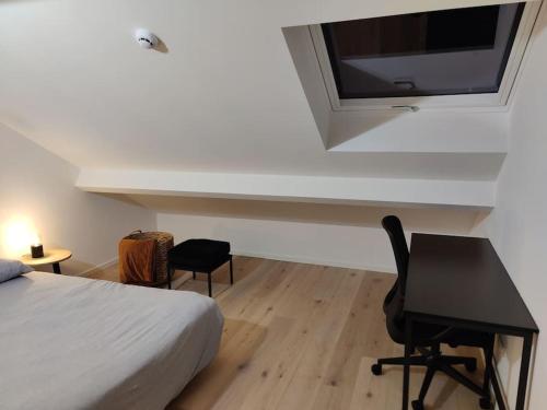 een slaapkamer met een bed, een bureau en een televisie bij Corso studio 0303 in Leuven