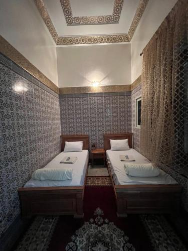 two twin beds in a room with a ceiling at Dar Yassine in Rabat