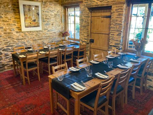 a dining room with a long table and chairs at Reillys Wines Heritage Cottages in Mintaro