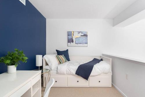 ein Schlafzimmer mit einem weißen Bett und blauen Wänden in der Unterkunft Modern Loft in Mission / Hayes Valley with Parking in San Francisco
