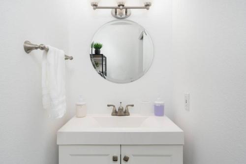 La salle de bains blanche est pourvue d'un lavabo et d'un miroir. dans l'établissement Modern Loft in Mission / Hayes Valley with Parking, à San Francisco