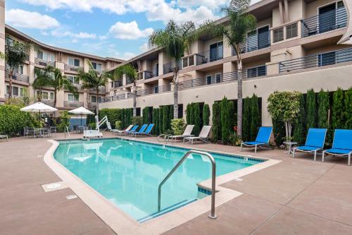 a swimming pool in a courtyard with chairs and a building at Best Western Plus Marina Gateway Hotel in National City