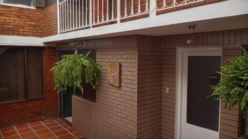un edificio de ladrillo con una puerta y una planta en Hotel Habitat Hospedaje, en Bogotá