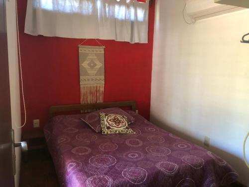 a small room with a purple bed with a window at calle 11 y 24 santa ana containers in Cuchilla Alta