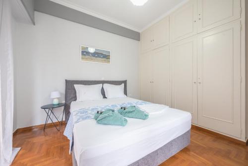 a bedroom with a white bed with towels on it at Andromar in the heart of Kolonaki in Athens