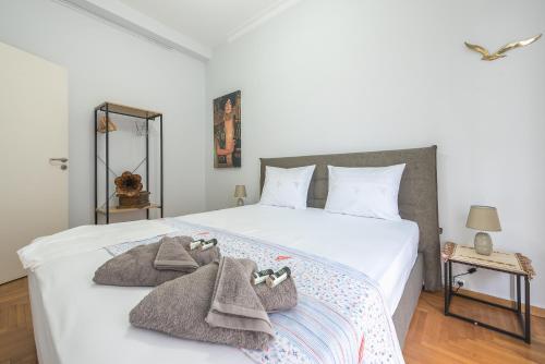 a bedroom with a white bed with towels on it at Andromar in the heart of Kolonaki in Athens