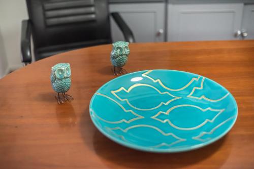 two owls are standing next to a plate on a table at Andromar in the heart of Kolonaki in Athens