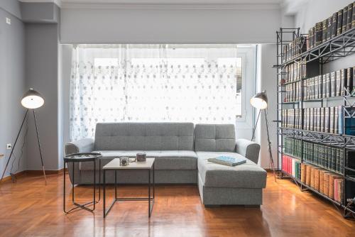 a living room with a couch and a table and bookshelves at Andromar in the heart of Kolonaki in Athens