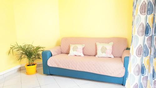a blue couch with two pillows on it in a room at Villas Ixora in Sainte-Anne