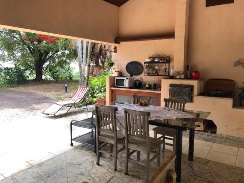 a kitchen with a table and chairs and a kitchen with a stove at Loft em chácara Espírito Santo in Espirito Santo Do Pinhal