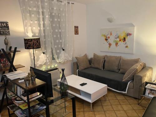 a living room with a couch and a table at Jolie, cozy et confortable maison de ville au calme à 1h30 de Paris gare de l'est en train in Belleville-sur-Meuse