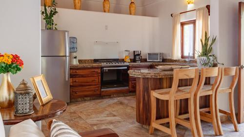 una cucina con frigorifero e tavolo con sedie di QUINTA BERNAL a Lo de Marcos