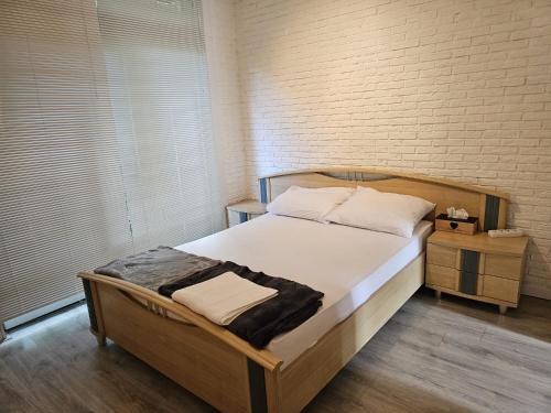 een slaapkamer met een groot bed en een bakstenen muur bij Nice house in Rotterdam