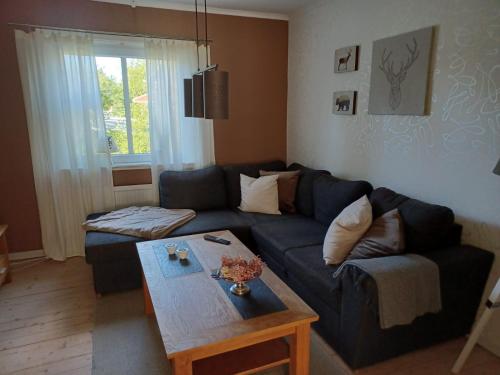 a living room with a blue couch and a table at Turmvilla Mörlunda in Mörlunda