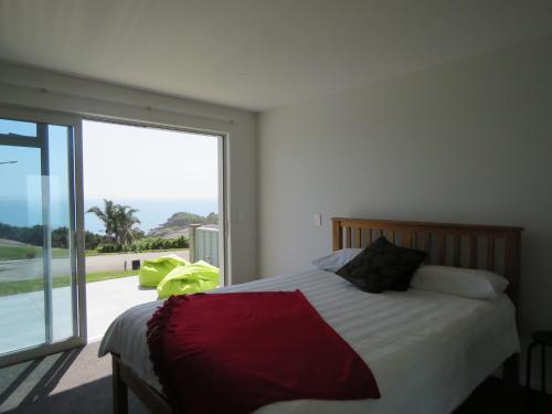 una camera con un letto e una grande finestra di Eagle View a Cable Bay