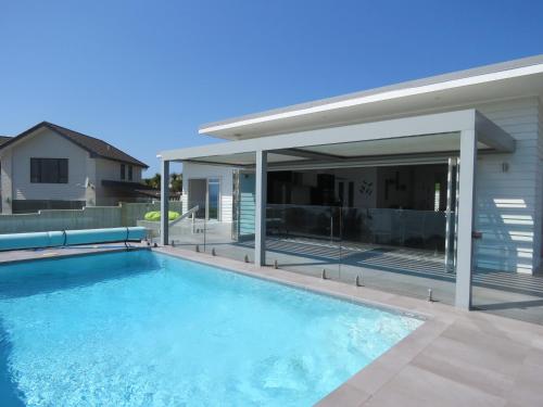 a swimming pool in front of a house at Eagle View in Cable Bay
