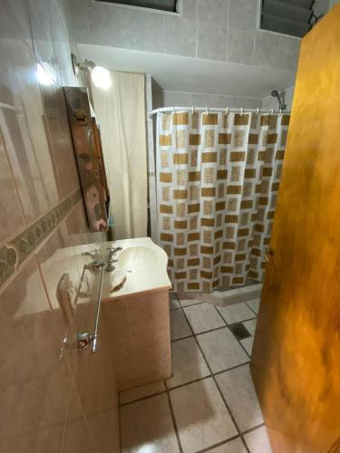 y baño con lavabo y ducha. en Departamento a metros del mar en Balneario Claromecó
