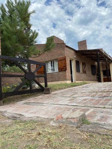 una casa de ladrillo con una valla delante de ella en Departamento a metros del mar en Balneario Claromecó