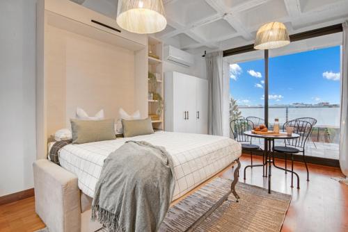 1 dormitorio con cama, mesa y balcón en Cozy Penthouse, 20 min to downtown, Alcalá Norte en Madrid